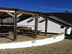 a patio with a roof with a table and chairs at The Anchor Inn in Ivybridge