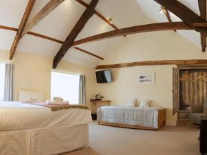 a large bedroom with two beds and a tv at The Anchor Inn in Ivybridge