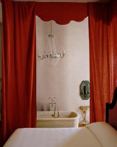 
a bathroom with a white sink and a red curtain at Hotel Peter and Paul in New Orleans
