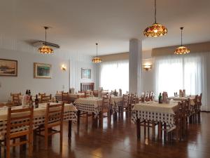 une salle à manger avec tables, chaises et fenêtres dans l'établissement Locanda Castagna, à Arzignano
