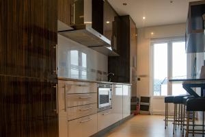 eine Küche mit Küchengeräten aus Edelstahl und einem großen Fenster in der Unterkunft Apartamento Ria de Foz in Foz