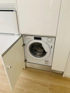 a washer and dryer in a kitchen with a door open at Moncloa-Arguelles nuevos pisos in Madrid