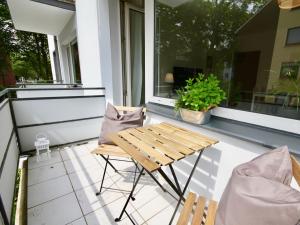 un patio con tavolo e sedie sul balcone. di Apartmenthaus in der Arnoldstraße a Bochum