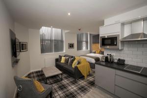 a kitchen and living room with a couch and a bed at 42 Apart-Hotel in Scunthorpe