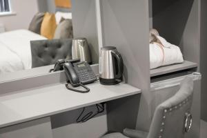 a room with a desk with a phone on a shelf at 42 Apart-Hotel in Scunthorpe
