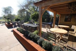 a patio with tables and chairs and a pavilion at The Carpenters Arms in Newbury