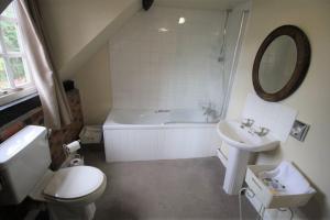 a bathroom with a tub and a toilet and a sink at The Carpenters Arms in Newbury