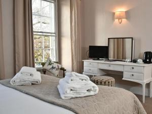 1 dormitorio con 1 cama con toallas en Lansdowne Strand en Calne