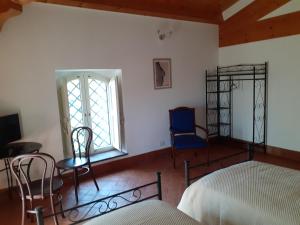 a bedroom with a bed and chairs and a window at Contrada Zerbate in Aci SantʼAntonio