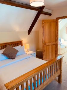 sypialnia z drewnianym łóżkiem i oknem w obiekcie The Granary w mieście Abergavenny