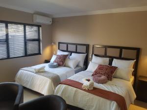 The Royal Prime Guest Lodge tesisinde bir odada yatak veya yataklar