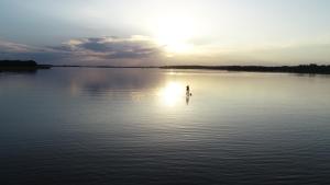 a person standing in the middle of a body of water at Stara Kuźnia Mazurska in Węgorzewo