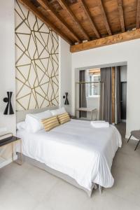 - une chambre avec un grand lit blanc et un plafond en bois dans l'établissement W Thyssen house, à Malaga