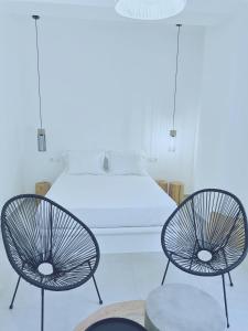 a bedroom with two chairs and a bed at Gardenia in Stavros