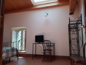 a room with chairs and a desk with a television at Contrada Zerbate in Aci SantʼAntonio