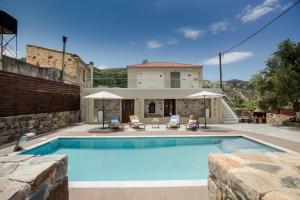 a villa with a swimming pool and a house at Tzouganos Villa in Sfinárion