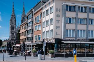 ein Gebäude in einer Stadtstraße mit einer Kirche in der Unterkunft Hotel du Bassin in Ostende