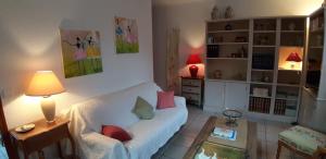a living room with a white couch and a table at Appartement 3 étoiles avec jardin privatif et parking in Aix-les-Bains
