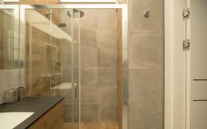 a shower with a glass door in a bathroom at Villa Wenecja Apartament ALBERO in Poznań