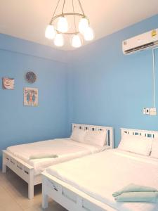 two beds in a room with blue walls at 350m to beach pool villa in Hua Hin