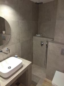 a bathroom with a sink and a shower at Ariadni Rooms & Apartments in Ermoupoli