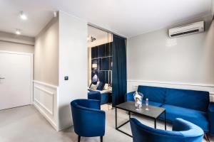 a living room with blue chairs and a blue couch at Villa Hoff Wellness & Spa in Trzęsacz