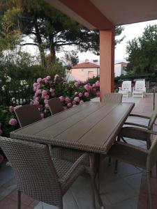 a wooden table and chairs on a patio with flowers at Apartment & Rooms Lilis in Izola