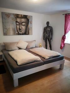 a bed in a room with a statue of a man at Ferienhaus HCR Grimmen in Grimmen