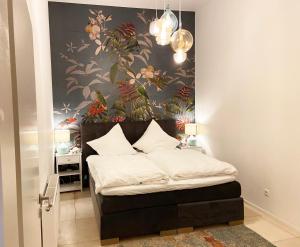 1 dormitorio con 1 cama y papel pintado con motivos florales en Loft directly next to Oktoberfest and downtown, en Múnich