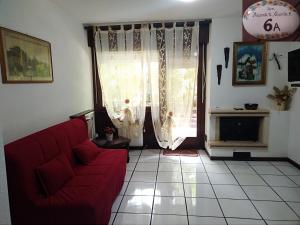 a living room with a red couch and a fireplace at Fam Pisconti App 6A Camigliatello in Camigliatello Silano