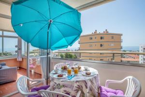 a table with a blue umbrella on a balcony at Sweet Holiday Place - Benalmadena Costa in Benalmádena