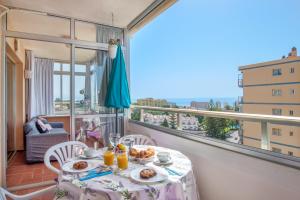 a table with plates of food on top of a balcony at Sweet Holiday Place - Benalmadena Costa in Benalmádena