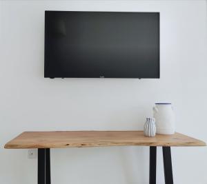 a flat screen tv on top of a wooden table at Gardenia Apartments in Stavros