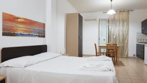 una camera con un letto bianco e un tavolo di Residence Catona a Otranto