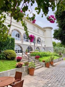 a building with a table and chairs and flowers at Hotel Casacurta in Garibaldi