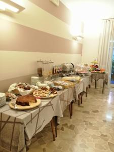 une rangée de tables contenant des assiettes de nourriture dans l'établissement Primavera, à Levanto