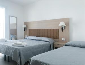 una camera d'albergo con due letti e uno specchio di Alba B&B a Cattolica