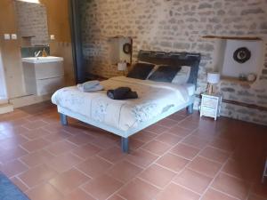 Alluyにあるgîte le tilleul de la Fontaineのレンガの壁、ベッド付きのベッドルーム1室