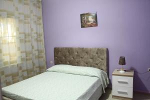 a bedroom with two beds and a purple wall at Hotel Marmara in Velipojë