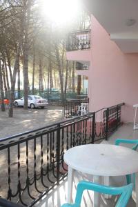 a table and chairs on a balcony with a car at Hotel Marmara in Velipojë