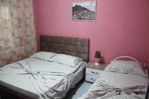 two beds in a bedroom with pink walls at Hotel Marmara in Velipojë