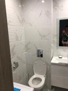 a bathroom with a toilet and a person taking a picture at Apartments na Solnechnoy 9 in Zelenogradsk