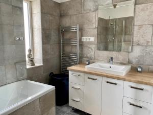 a bathroom with a tub and a sink and a bath tub at Royal Blue - luxurious flat with 5-star view over Lake Balaton in Keszthely