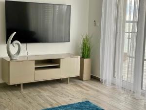 sala de estar con TV de pantalla plana en la pared en Royal Blue - luxurious flat with 5-star view over Lake Balaton, en Keszthely