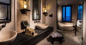 a bathroom with two sinks and two tubs in it at Alila Jabal Akhdar in Al Khuţaym
