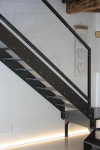 a black metal staircase in a house with white walls at Onda Marina B&B Superior in Marano Lagunare