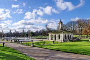 a building in the middle of a park with a fountain at Lancaster Hall Hotel in London