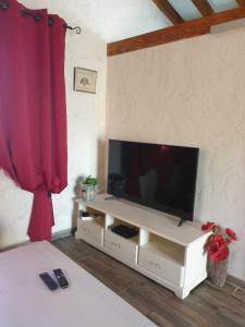 a living room with a television on a white entertainment center at A Teppa in Luri