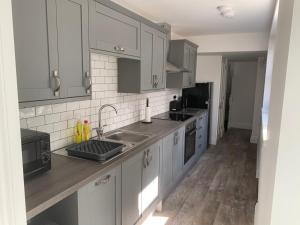 a kitchen with white cabinets and a sink at Amazing Luxury Beach Front Apartment in Margate