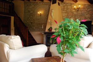 sala de estar con sofá blanco y planta en Castell de Riudabella, en Vimbodí